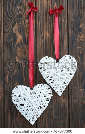 
Wedding white hearts on red strip 
hanging on wooden vintage door