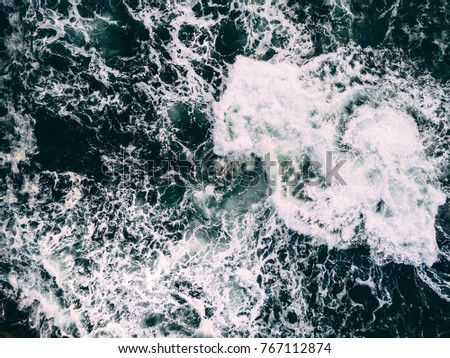Huge wave smashing into underwater rock, seen from above