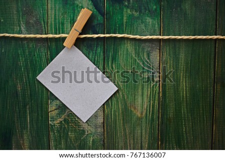 Paper Blank Hanging at Clothesline on Green Wood Background with Copy Space Card 
