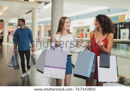 Girls are shopping at the mall. Sale in black Friday. Girls are shopping on a black Friday. Two girls chat during shopping and have fun.