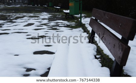 Bench on it snow in park