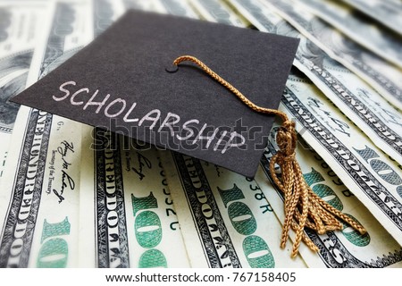 Scholarship graduation cap on money                 Royalty-Free Stock Photo #767158405