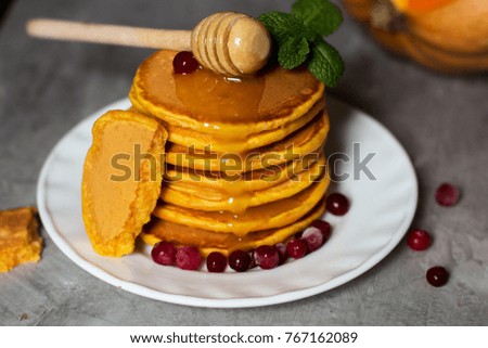 pumpkin pancakes with honey on a gray wooden background