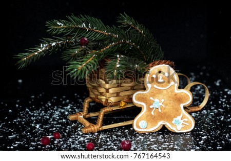 Christmas gingerbread, little man. Branches were eaten in sleds. Dark background