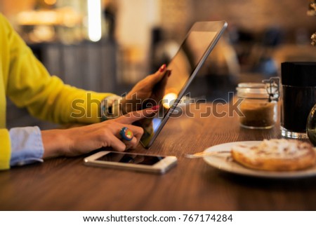 Woman using tablet computer in cafe.