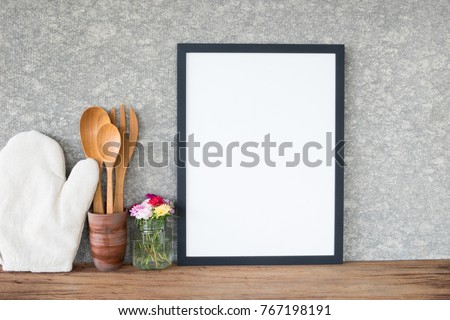 Frame poster with utensil and flower in vase on table.cooking concept