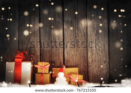 Christmas Gifts on snow, cold light, rustic wooden background
