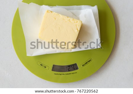 Weighting a stick of butter in preparation for cooking Royalty-Free Stock Photo #767220562