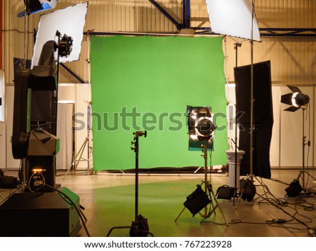 Real empty green screen (Chroma key) film/photo studio with lighting/studio equipment
