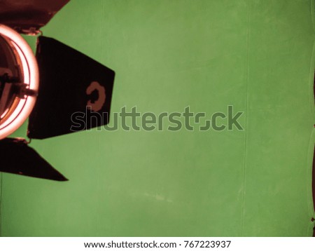 Real empty green screen (Chroma key) film/photo studio with luminous lamp