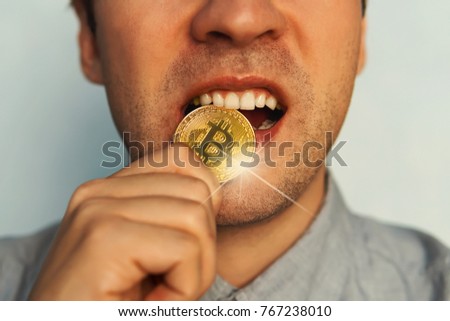 man with one gold bitcoin coin on a tooth. Test of strength gold coin bitcoin.