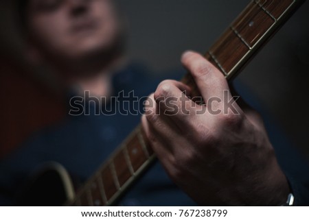 The Guitarist Guy plays the guitar in a bar in a beautiful setting on a high bar stool