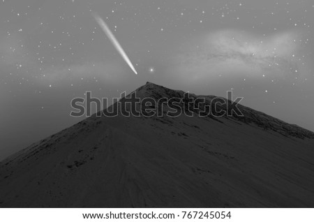 High sand mountain with bright comet over the top