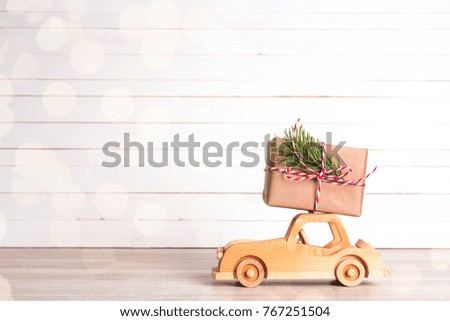 Gift box on wooden toy car. Christmas holiday celebration concept. Copy space.
