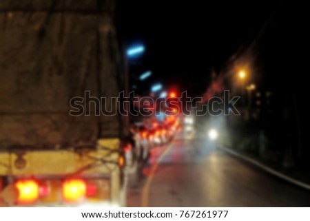 Blur Red taillight of cars, truck with red traffic light on the road and traffic jam in the evening  