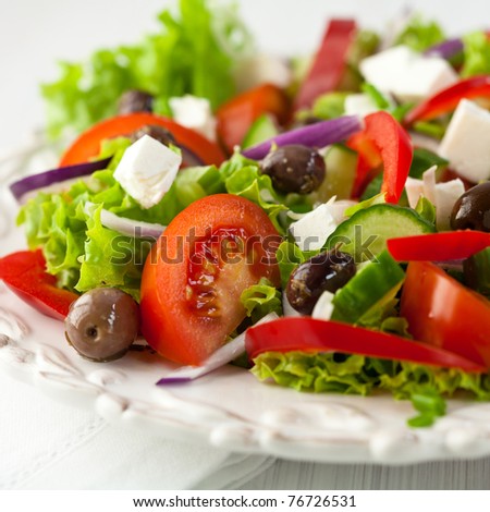 Greek salad with feta cheese, organic kalamata olives, juicy tomatoes, red pepper, red onion, cucumber and lettuce. Concept for healthy nutrition. Tasty and healthy vegetarian meal. Close up.  Royalty-Free Stock Photo #76726531
