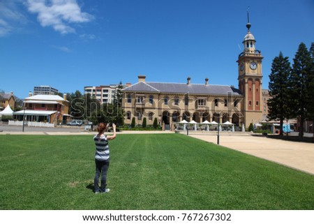 A woman takes a photo of Customs House a local landmark in Newcastle - Australia's second oldest city. Newcastle has some beautiful architecture such as this building built more than 100 years ago