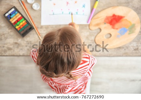 Little girl painting at table