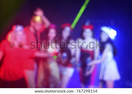 Blur picture of new year Party with friends in the nightclub and dancing with people in the party. The friends celebrating and drinking with night light background
