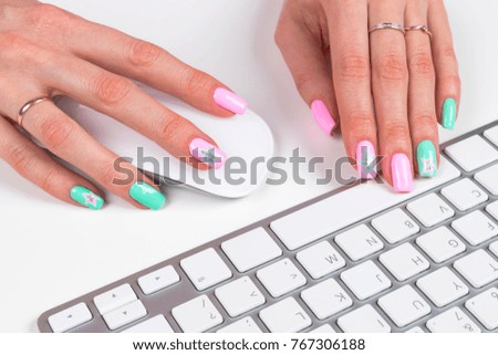 Closeup view of a business woman hands typing on wireless computer keyboard on office table and using mouse. Soft lightning