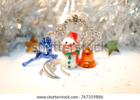 Snow man with ornaments, christmas decoration on white ground and glitter silver background