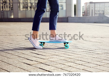 Hipster girl skateboarding outdoors