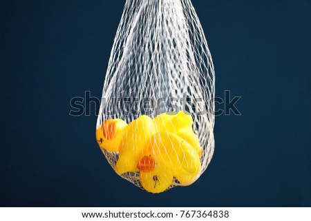 Duck dolls made of rubber in mesh bag.On a blue background