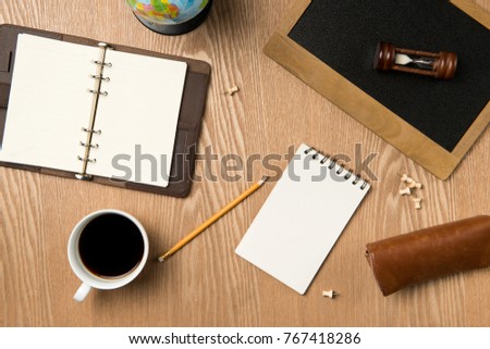 Business planning concept. Top view of hand writing on a blank notebook with hot coffee.