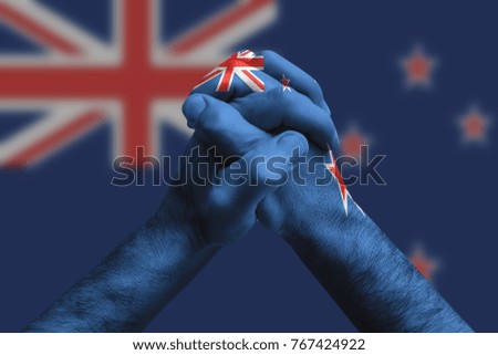 Clasped hands patterned with the New zealand flag, multi purpose concept - isolated on flag background