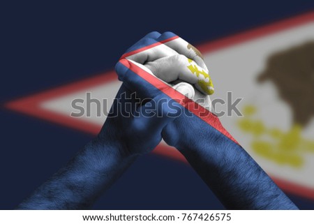 Clasped hands patterned with the American samoa flag, multi purpose concept - isolated on flag background