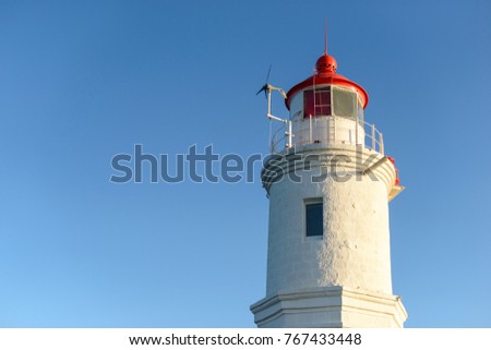 Lighthouse on the seacoast at sunset light. Nature background. Free copy space.