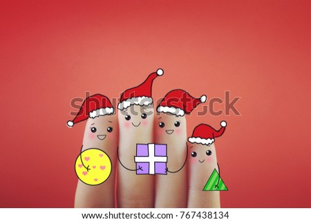 Four fingers decorated as a family celebrating Christmas happily .