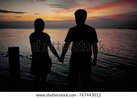 Couples holding hands together a twilight evening light and low light.