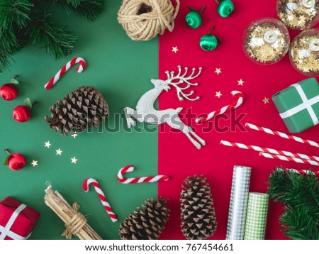 top view of Christmas and new year holidays concept with Pine cones, gift box, Christmas ball, and Christmas decorations on red and green color paper background