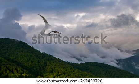 pterodactyl soaring in the fog on a forested mountainside