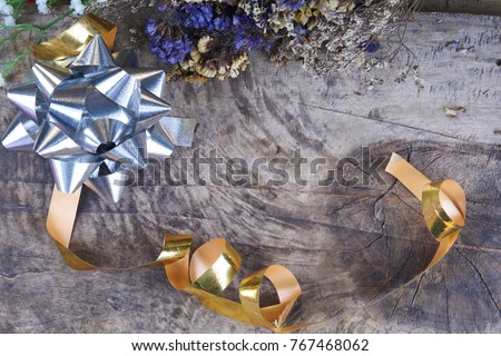Beautiful star ribbons and flowers. Happy new year with colorful and shiny bows on the wood background.