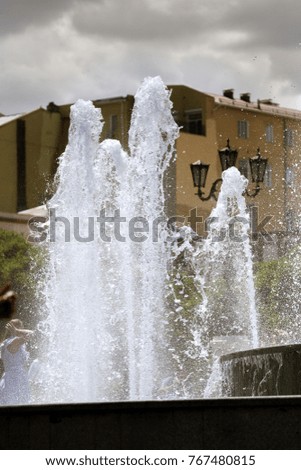 City fountain. Fountain in city park on hot summer day. stream of water, drops and bright splashes of water in beautiful city fountain. Bright streams of sparkling water in city fountain