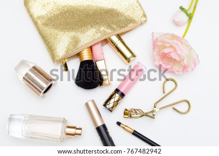Cosmetic products of gold color on a white background. Flat lay