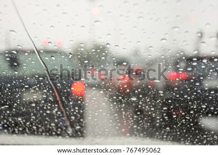 View of road and traffic jams on a rainy day from inside a car with the wet car glass.