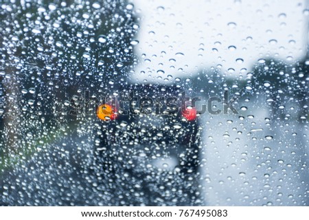 Road view through car window with raindrops.