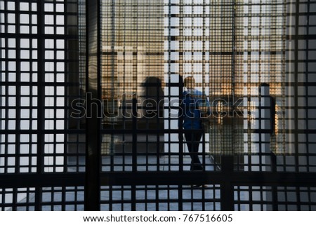 Abstract image of windows reflercting in windows, with people inside building