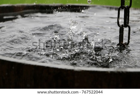 rain is falling into a barrel full of water