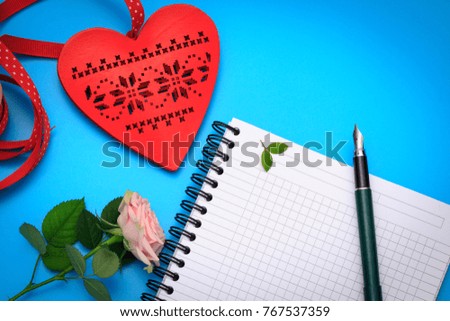Flat lay Valentine scene with blank notebook, heart, pen and rose. Concept of Valentine letter.