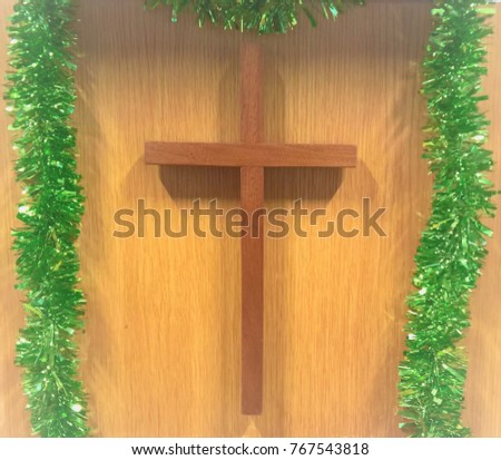 Cross and green Christmas Tinsel. Christian christmas background 