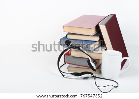 Open book, hardback colorful books on wooden table, white background. Back to school. Headphones, cup. Copy space for text. Education business concept