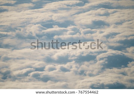 aerial shot from plane flying above the clouds in daytime