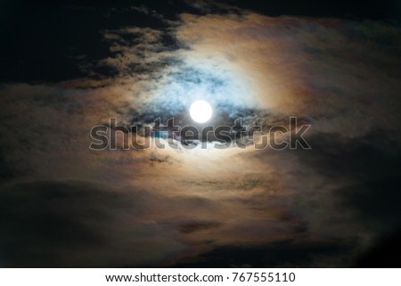 The moon shines through the clouds