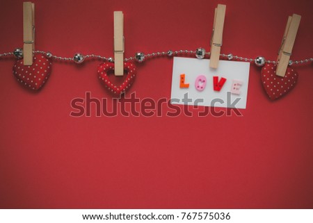 Table top view aerial image of valentines day background concept.Beautiful decorations season hanging on gem clothesline and greeting card.Several objects on modern  red wallpaper with copy space.