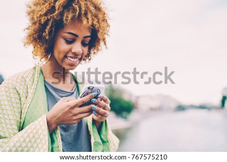 Cropped image of attractive smiling female blogger enjoying leisure time sharing and discussing ideas with followers in personal website.Young happy cute woman recreating outside with modern device