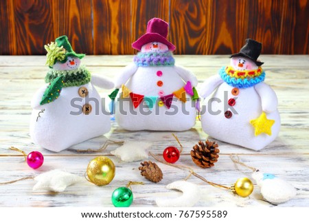 Group of three soft handmade toy snowmen. New Year's decor, symbol. New Year celebration.